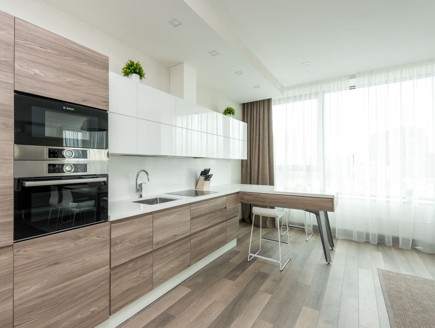 Cozinha planejada em MDF amadeirado com armários aéreos brancos